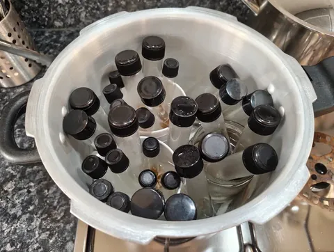 Pressure cooker filled with screw-cap test tubes, some containing liquid